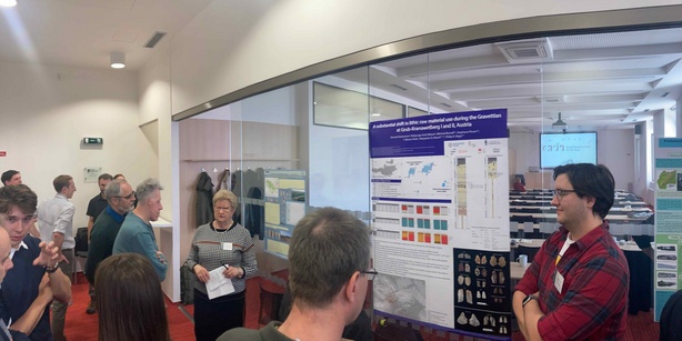 Samuel Kasemann next to his poster at the conference, other people 